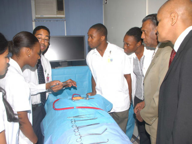 Dr. Roger Irving (third left), demonstrates the cardiac simulator to students, W. Billy Heaven, CEO of the CHASE Fund (second right) and Prof. Ivor Crandon of the UHWI (right).  The cardiac simulator, developed by local scientists, is one of the many simulators housed in the state-of-the-art CHASE Carnegie Surgical Skills Laboratory, which was opened in July 2011 in memory of Dr. Alfred Carnegie, an outstanding Jamaican surgeon.  The laboratory is used for basic and advanced training - in all disciplines of surgery - through the use of simulators, telescopes, patient models, cadavers and anaesthetized small animals. The Laboratory, which also offers distance teaching and video conferencing, was established with a contribution of approximately J$25 million from CHASE.