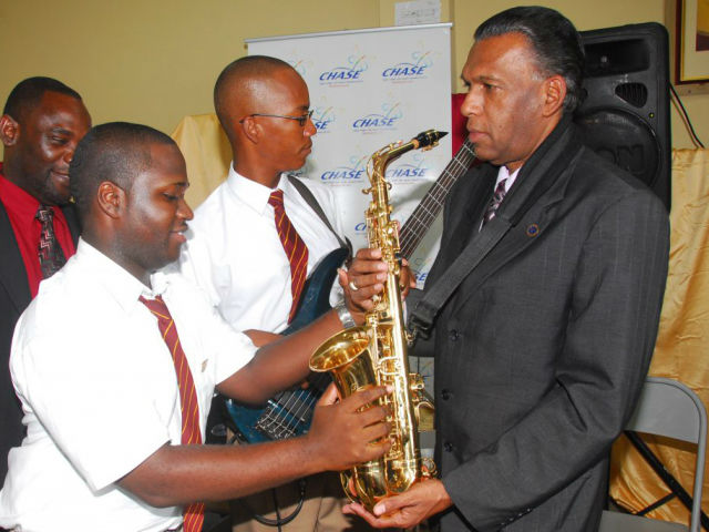 W. Billy Heaven gets instruction on the sax from a member of the Wolmers Boys’ School band.  The Wolmer’s Boy’s School received the sum of $1 million from the CHASE Fund to establish an extra-curricular music programme and start a marching band boost to its music programme in 2008.