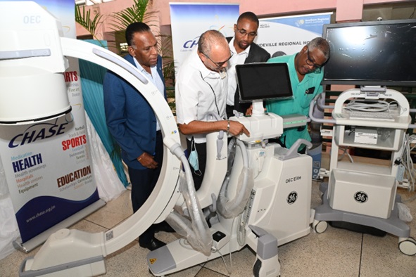 Dr. Steve Mullings (2nd left), Orthopaedic Consultant and Head of the Orthopaedic Department at the Mandeville Regional Hospital, highlights the special features of the C-Arm machine with (L-R) W. Billy Heaven, CEO, CHASE Fund; Omar Frith, Chairman, CHASE Fund; and Dr. Everton McIntosh, Senior Medical Officer Mandeville Regional Hospital.