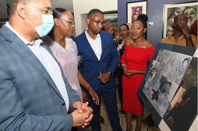 Rose Bennett-Cooper, Chairman of the Cecil Cooper Foundation (right), highlights one of the 70 works by the late Cecil Cooper, curated for the Cecil Cooper Foundation Exhibition. Viewing the artwork were (left - right), Prime Minister Andrew Holness, Mrs. Juliet Holness, Patron of the Cecil Cooper Foundation and Omar Frith, Chairman, CHASE Fund.