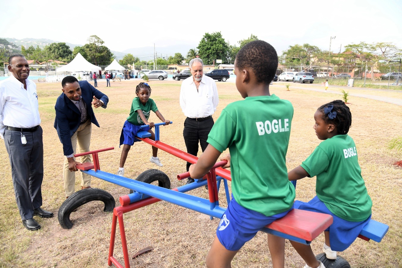 CHASE CEO, W. Billy Heaven, Chairman Omar Frith and Director Ian Levy interact with children enjoying the play equipment at the Pembroke Hall Wellness Park.
