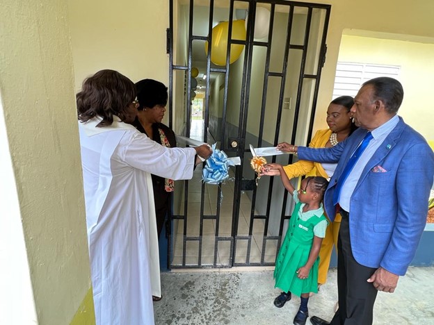 The ribbon is cut to open the new school block at the Savanna La Mar Infant School by (L-R) Rev. Opal Beharie, Chairman of the Savanna La Mar Infant School, Dr Michelle Pinnock, director of Region Four in the Ministry of Education, Praise Thompson-Brown, Principal assisted by student, Leana Barker and W. Billy Heaven, CEO of the CHASE Fund.