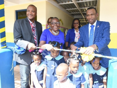 CHASE CEO, W. Billy Heaven, cuts the ribbon to open the new school building on November 14, 2019.  With him are from left: Member of Parliament, Victor Thomas; Principal, Pauline White-Anderson; and Veneisha Morgridge, Education Officer Region 3; and Unity Primary and Infant School students.